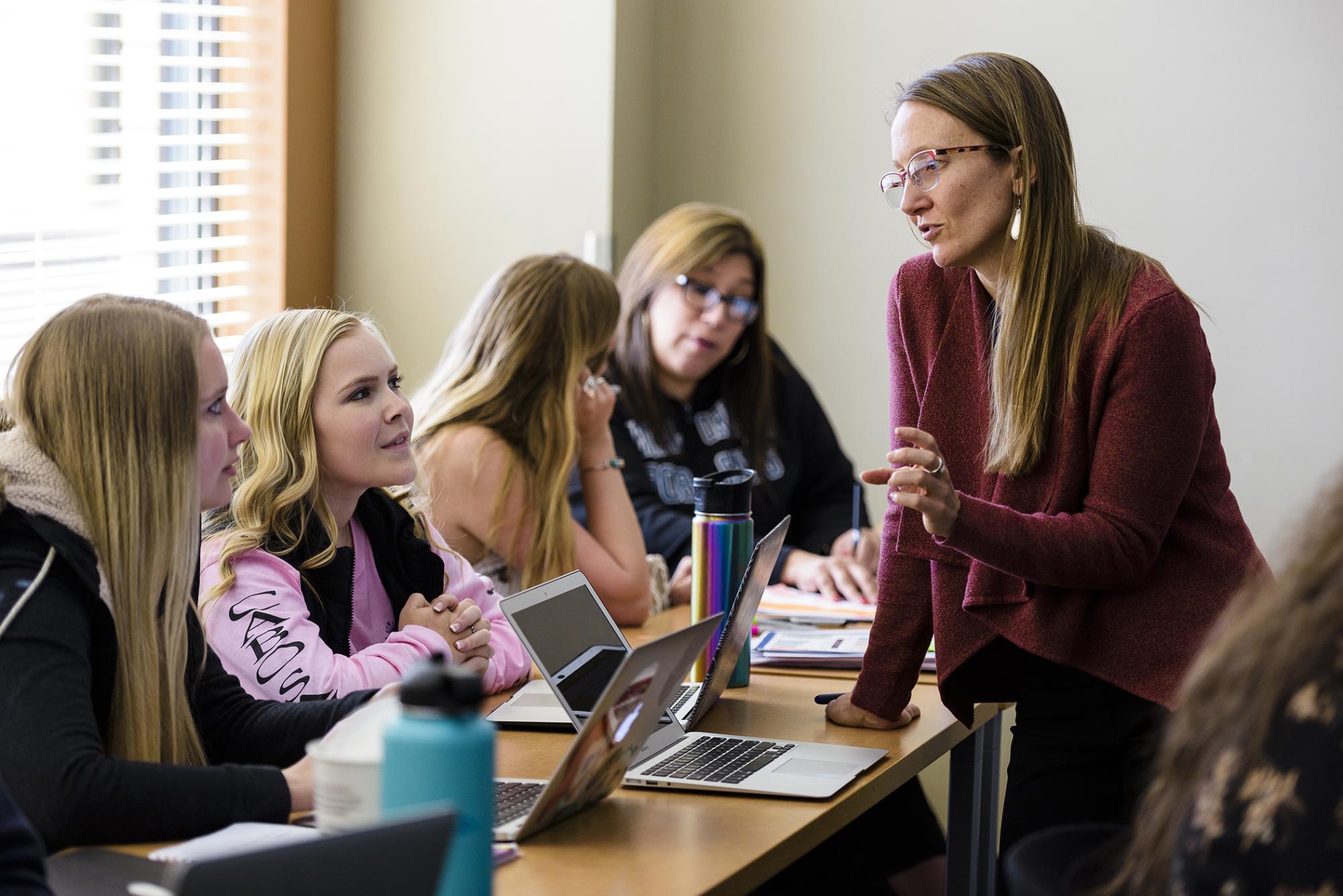 Woman is talking to students at a table