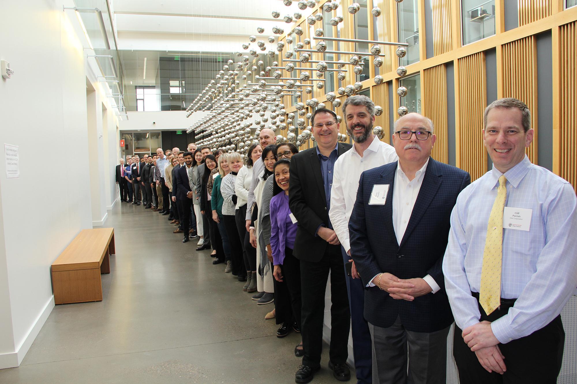 Men and women and business attire in long line in modern building hallway