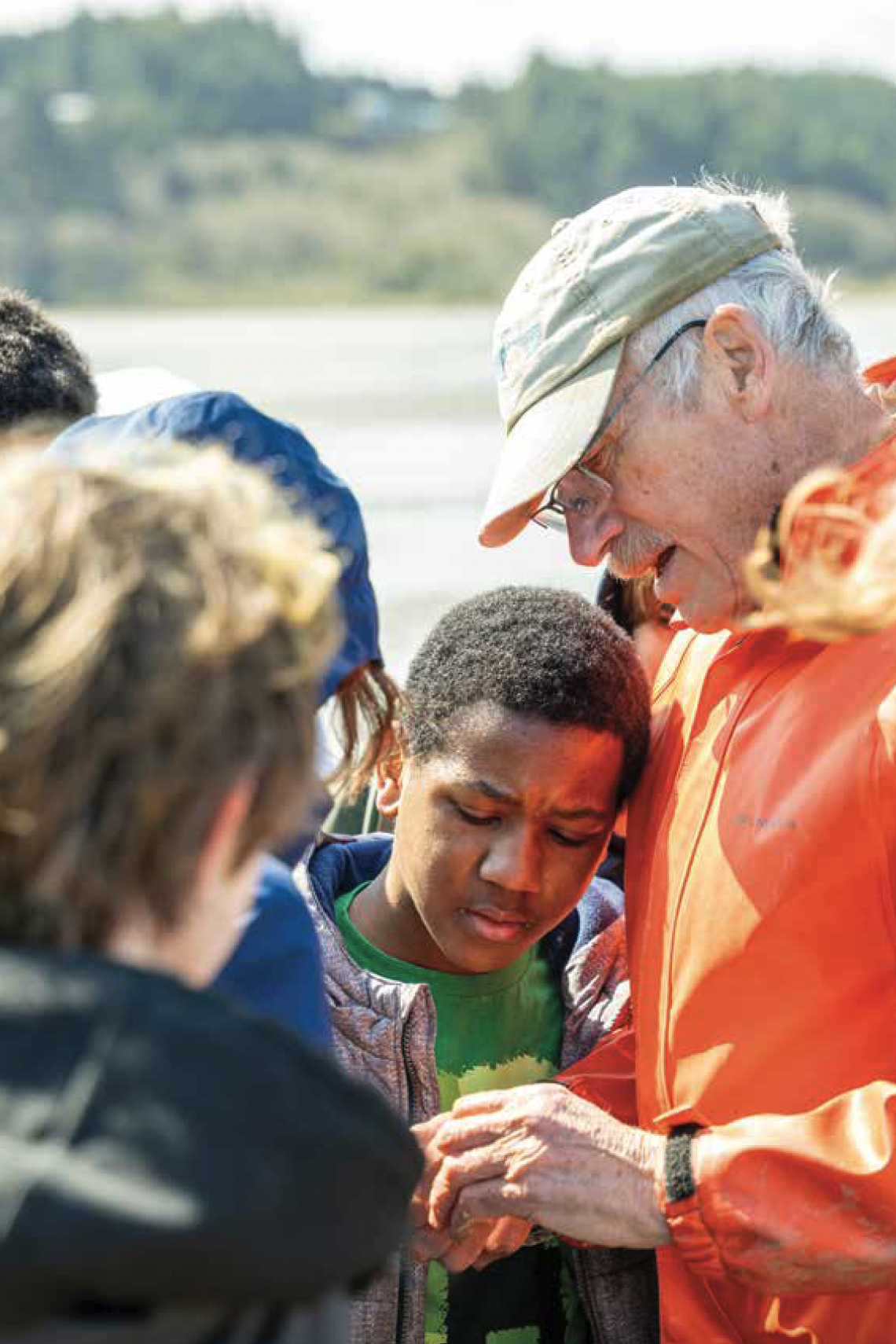 Man showing youth something near the ocean side